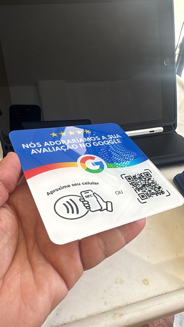 Plaquinha NFC azul de avaliações no Google segurada na mão