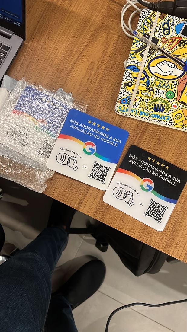 Duas plaquinhas NFC, uma azul e uma preta, sobre a mesa
